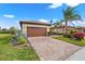 Charming single-Gathering home featuring a brick driveway, lush landscaping, and a two-car garage at 12837 Oriago St, Venice, FL 34293