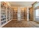 Elegant library featuring floor-to-ceiling bookshelves filled with a vast collection of literary works at 12837 Oriago St, Venice, FL 34293