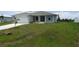 Newly constructed one-story home with attached garage and grassy yard at 14464 Fort Myers Ave, Port Charlotte, FL 33981