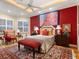 Spacious bedroom with red accents and an ornate area rug at 1720 Grande Park Dr, Englewood, FL 34223
