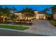 Attractive home at night with lights illuminating landscaping at 1720 Grande Park Dr, Englewood, FL 34223