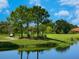 Golf course with golfers and a pond at 1720 Grande Park Dr, Englewood, FL 34223