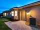 Tan house exterior at dusk with garage and walkway at 1720 Grande Park Dr, Englewood, FL 34223