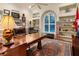 Home office with large desk, built-in shelving, and rich wood tones at 1720 Grande Park Dr, Englewood, FL 34223