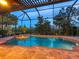 Inviting screened pool with a spa and lush landscaping at 1720 Grande Park Dr, Englewood, FL 34223