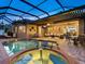 Stunning pool and spa area with a covered patio and outdoor kitchen at 1720 Grande Park Dr, Englewood, FL 34223