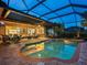 Large screened-in pool with brick pavers and a covered patio at 1720 Grande Park Dr, Englewood, FL 34223