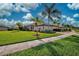 Single-story home with lush lawn, palm trees, and a paved driveway at 20272 Tesoro Dr, Venice, FL 34293