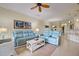 Open living room featuring light blue sofas and a view into the kitchen and dining area at 20272 Tesoro Dr, Venice, FL 34293