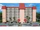 Front view of a tall residential building with red roof and ample parking at 232 Saint Augustine Ave # 404, Venice, FL 34285