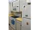 View of kitchen with electric stovetop, microwave, and white refrigerator at 232 Saint Augustine Ave # 404, Venice, FL 34285