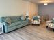 Living room with teal sofa, armchairs, and wood-look flooring at 232 Saint Augustine Ave # 404, Venice, FL 34285