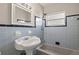 Bathroom with blue tiled walls, tub and pedestal sink at 370 Waltham St, Port Charlotte, FL 33952