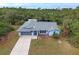 Single-story house with a gray roof, driveway and a large backyard at 419 Ramblewood St, Port Charlotte, FL 33953