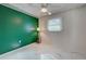 Bright bedroom with green accent wall, ceiling fan, and tile floors at 419 Ramblewood St, Port Charlotte, FL 33953