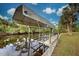 Covered boat lift on a canal with a dock at 419 Ramblewood St, Port Charlotte, FL 33953