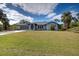 Single-story home with gray roof, screened porch, and large yard at 419 Ramblewood St, Port Charlotte, FL 33953