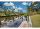 Wooden dock on a calm canal with trees at 419 Ramblewood St, Port Charlotte, FL 33953