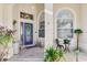 Inviting front entry with a blue door, tile flooring, and potted plants at 5039 Bella Terra Dr, Venice, FL 34293