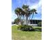 Landscaped yard with palm trees and a white single-wide home at 536 Amberjack Dr, North Port, FL 34287