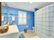 Bright blue bathroom with shower and striped curtain at 555 Circlewood Dr # T10, Venice, FL 34293