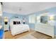 Light blue bedroom with white dresser and bedding at 555 Circlewood Dr # T10, Venice, FL 34293