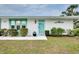 White house with teal door and window accents, landscaping, and a short walkway at 555 Circlewood Dr # T10, Venice, FL 34293