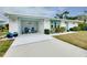 Front view of a charming white house with teal accents and carport at 555 Circlewood Dr # T10, Venice, FL 34293