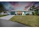 Cute Florida home with teal door, carport, and well-manicured lawn at 555 Circlewood Dr # T10, Venice, FL 34293