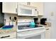 White cabinets, granite countertop, stovetop and microwave at 555 Circlewood Dr # T10, Venice, FL 34293