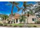 Tan house with red tile roof, palm trees, and lush landscaping at 601 Tyson Ter # 1, Venice, FL 34285