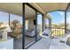 Screened balcony with white wicker furniture and sliding glass doors leading to the living area at 612 Bird Bay S Dr # 309, Venice, FL 34285