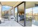 Screened balcony with white wicker furniture and sliding glass doors leading to the living area at 612 Bird Bay S Dr # 309, Venice, FL 34285