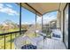 Screened balcony with white wicker furniture, overlooking a lush green space at 612 Bird Bay S Dr # 309, Venice, FL 34285