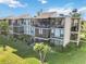 Condo building with multiple units, lush landscaping, and a sunny day at 612 Bird Bay S Dr # 309, Venice, FL 34285