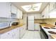 Efficient kitchen featuring white cabinetry, wood countertops, and modern appliances at 612 Bird Bay S Dr # 309, Venice, FL 34285