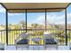 Relaxing screened balcony with patio furniture and view of lush landscape at 612 Bird Bay S Dr # 309, Venice, FL 34285
