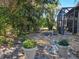 Peaceful backyard featuring a stone pathway, lush foliage, and potted plants at 624 Silk Oak Dr, Venice, FL 34293