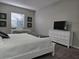 Bedroom with white dresser, TV and window with blinds at 624 Silk Oak Dr, Venice, FL 34293