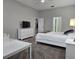 Bedroom with TV, white dresser and ensuite bath at 624 Silk Oak Dr, Venice, FL 34293