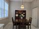 Kitchen dining area with dark wood table and white plantation shutters at 624 Silk Oak Dr, Venice, FL 34293