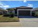One story home with brown roof, attached garage, and manicured lawn at 624 Silk Oak Dr, Venice, FL 34293