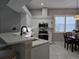 Modern kitchen with white shaker cabinets, stainless steel appliances, and quartz countertops at 624 Silk Oak Dr, Venice, FL 34293
