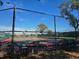 Community tennis court with seating area, surrounded by a chain link fence at 624 Silk Oak Dr, Venice, FL 34293
