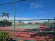 Community tennis court behind a chain link fence with trees in the background at 624 Silk Oak Dr, Venice, FL 34293