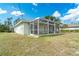 Enclosed patio with screen and backyard on a sunny day at 6502 Whelan St, Englewood, FL 34224