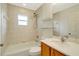 Bathroom with a tiled shower-tub combination, single vanity, and window for natural light at 6502 Whelan St, Englewood, FL 34224