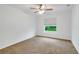 Clean bedroom features neutral carpet, a ceiling fan, and a window with green outdoor views at 6502 Whelan St, Englewood, FL 34224