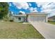 Inviting single-story home featuring a well-manicured lawn, wide driveway, and a cozy front porch at 6502 Whelan St, Englewood, FL 34224