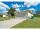 Spacious two-car garage with a long driveway, complemented by the home's exterior and greenery at 6502 Whelan St, Englewood, FL 34224